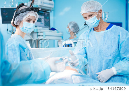 Serious assistant looking at male hands Serious assistant looking at male hands 34167809