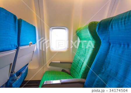 Airplane seat near windows in cabin of aircraft Airplane seat near windows in cabin of aircraft 34174504