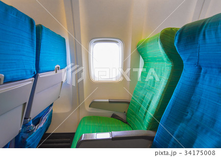 Airplane seat near windows in cabin of aircraft 34175008