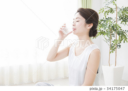 コップの水を飲む女性の写真素材