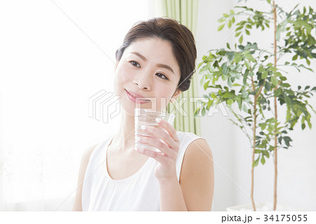 コップの水を飲む女性の写真素材