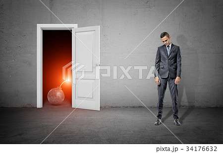 A sad businessman stands with shoulders slumped A sad businessman stands with shoulders slumped 34176632