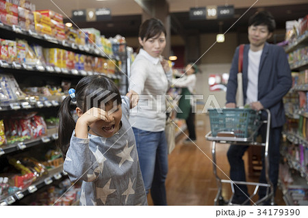 スーパーのお菓子売り場で大泣きをする子供の写真素材