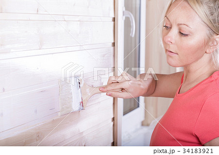 Woman painting wooden boards in white color Woman painting wooden boards in white color 34183921