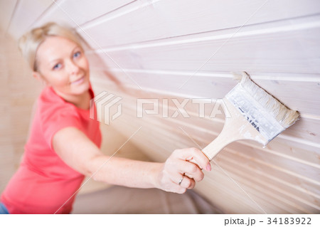 Woman painting wooden boards in white color Woman painting wooden boards in white color 34183922