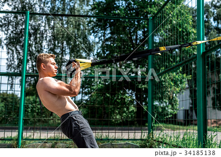 Male athlete, trains in fresh air, summer trx Male athlete, trains in fresh air, summer trx 34185138