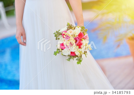 Bride in wedding dress holds her rouses bouquet Bride in wedding dress holds her rouses bouquet 34185793