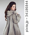Fashionable woman in mink fur coat over studio 34186844