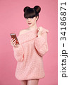 Brunette holding mobile telephone. Fashion studio 34186871