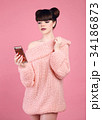 Brunette holding mobile phone. Fashion studio teen 34186873