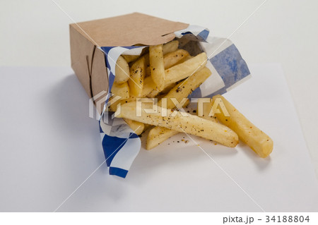 Hamburger and french fries in a take away container on table 34188804