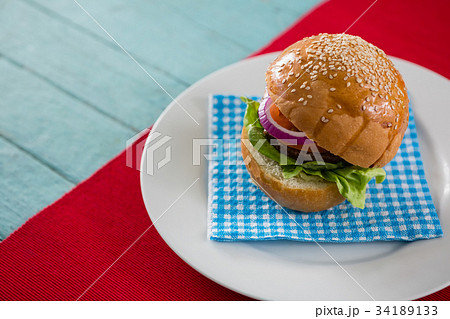 French fries in container by burger on cutting board with drink French fries in container by burger on cutting board with drink 34189133