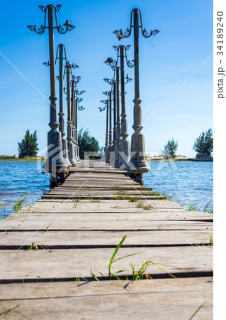 The wood pier and light posst in pond The wood pier and light posst in pond 34189240