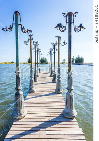 Light posts and wood pier in pond 34189261