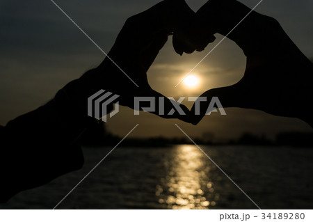 Hand shaped heart in sunrise Hand shaped heart in sunrise 34189280