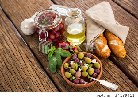 Close up of brown olives with herb in ladle Close up of brown olives with herb in ladle 34189411