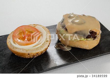 Hamburger, onion ring and french fries with cold drink on chopping board 34189599
