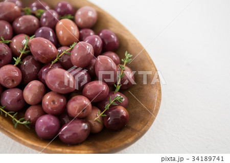Green olives, fresh herbs with olive oil and red chilies on table 34189741