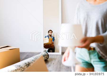 Young couple moving in new house, cardboard boxes. 34193975