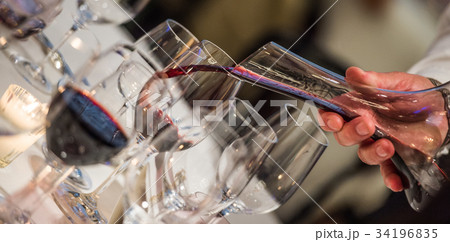 Sommelier pouring wine into glass from mixing bowl 34196835