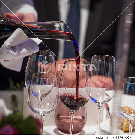 Sommelier pouring wine into glass from mixing bowl 34196837