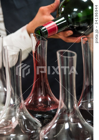 Sommelier at work, pouring wine to decanter while 34196944
