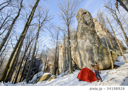 Male hiker nearly his red tent in the mountains 34198926