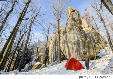 Male hiker nearly his red tent in the mountains 34198927