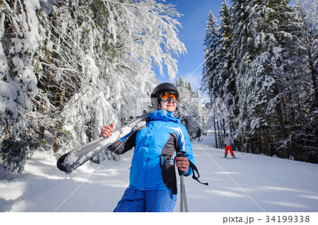 Happy woman skier on a ski slope in the forest 34199338