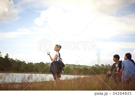 a girl is watching the sunset with her friends on a riverside 34204935