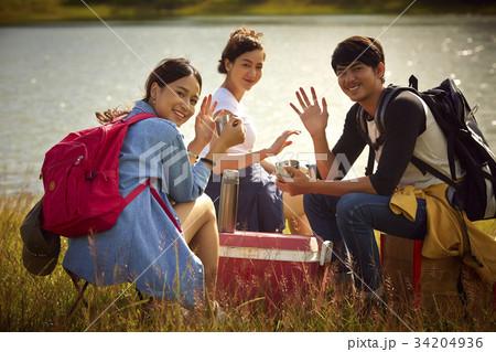 A group of friends is smiling and waving hand on the riverside A group of friends is smiling and waving hand on the riverside 34204936