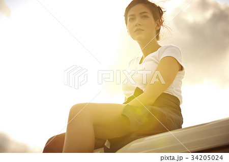a young girl is sitting on truck's roof outdoors a young girl is sitting on truck's roof outdoors 34205024