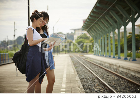 two asian female travelers are standing near railway 34205053