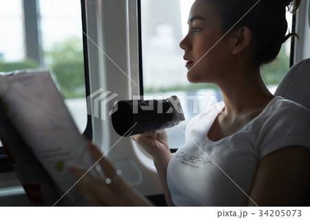 a girl is holding camera and map and sitting inside a truck 34205073