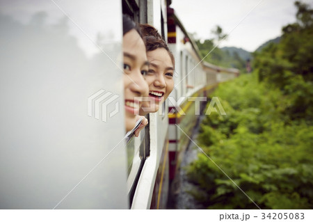 two lovely girls are enjoying scenery from the train 34205083