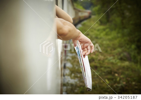 Someone is holding a map and putting outside of the train. Someone is holding a map and putting outside of the train. 34205187