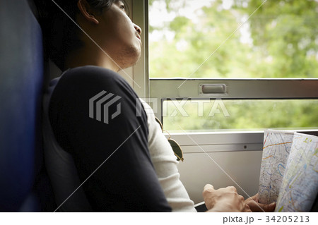 The man is watching the sky through the train window. The man is watching the sky through the train window. 34205213