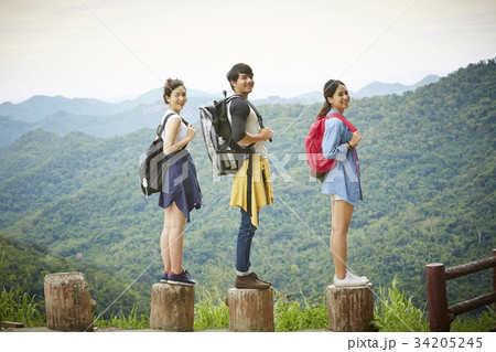 three friends are standing on a high place and posing 34205245