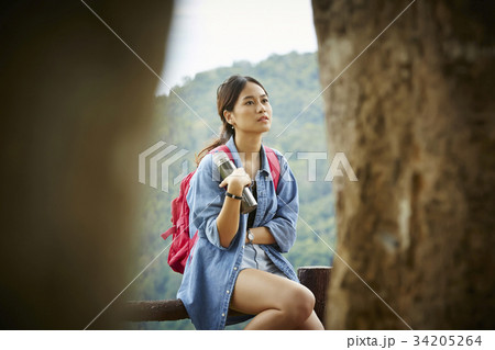 The girl is sitting on the fence to rest 34205264