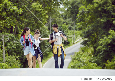 The girl is teasing her two friends on a road The girl is teasing her two friends on a road 34205265