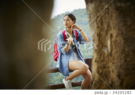 The girl is sitting and wiping sweat from her cheeks after a long trip 34205282