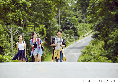 three dynamic people are talking together when walking in the jungle 34205324