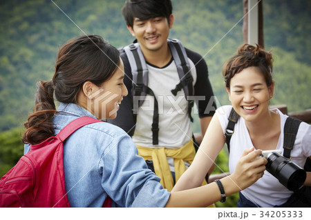 A pretty girl is sharing photo in her camera with friends A pretty girl is sharing photo in her camera with friends 34205333