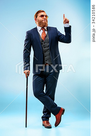 The barded man in a suit holding cane. The barded man in a suit holding cane. 34210586
