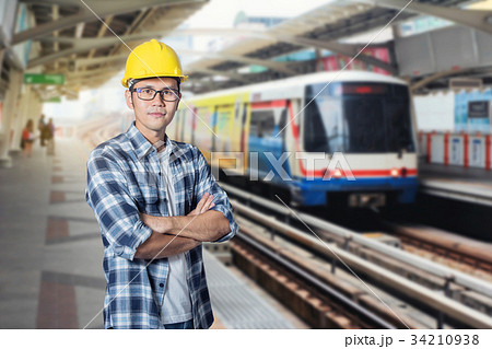 Asia young man in helmet stand with arms crossed Asia young man in helmet stand with arms crossed 34210938