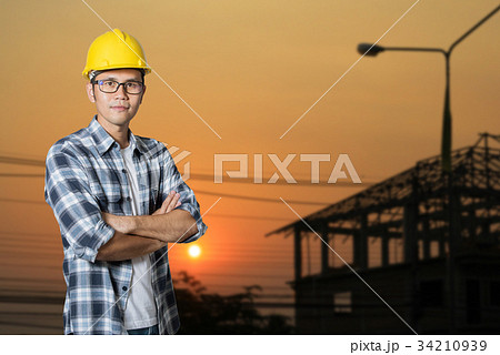 Asia young man in helmet stand with arms crossed Asia young man in helmet stand with arms crossed 34210939