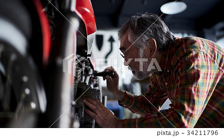 バイクを修理するシニア男性 バイクを修理するシニア男性 34211796