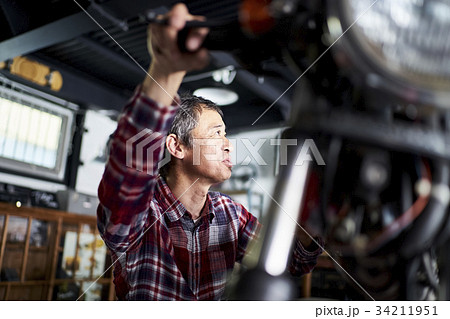 バイクを修理するシニア男性 バイクを修理するシニア男性 34211951