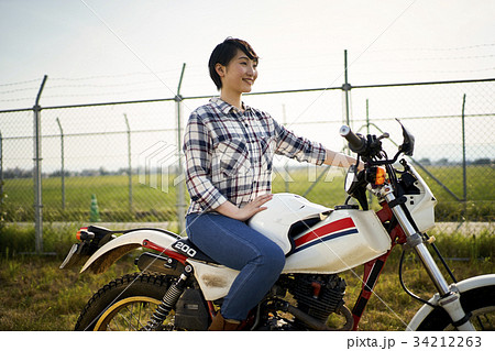 バイクにまたがる女性の写真素材