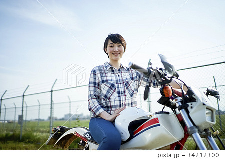 バイクにまたがる女性の写真素材